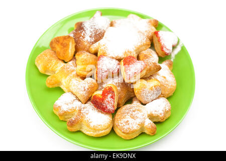 Cookies mit pulverisiertem Zucker auf einen Teller, isoliert auf weiss Stockfoto