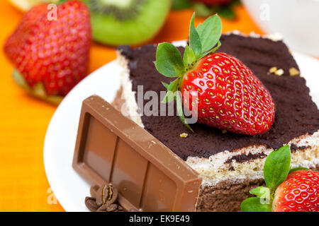 Tee mit Zitrone, Schokolade, Kiwi, Kuchen und Erdbeeren auf der Ora liegend Stockfoto