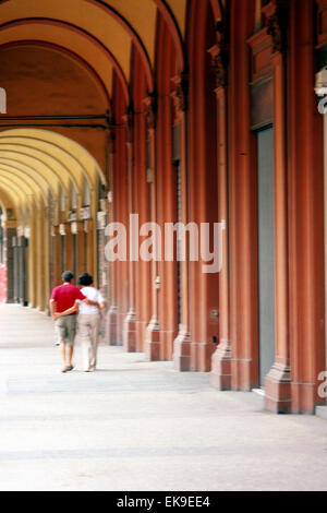 Italien, Emilia Romagna, Bologna, paar zu Fuß entlang einer gesäumten Arkaden Stockfoto