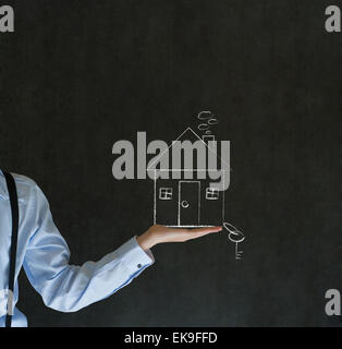Mann mit Kreide Haus oder Immobilien und Schlüssel Stockfoto