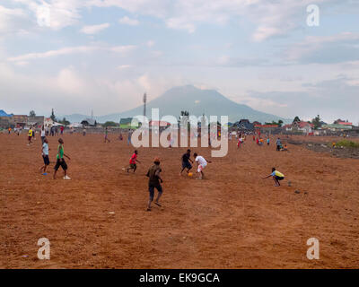 Afrikanische Kinder Fußball spielen; Goma, mit dem Vulkan Mount Nyriagongo, demokratische Republik Kongo (DRC), Afrika Stockfoto