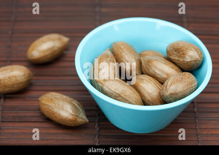 Pekannüsse in einer Schüssel auf einer Bambusmatte Stockfoto