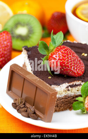 Tee mit Zitrone, Schokolade, Kiwi, Kuchen und Erdbeeren auf der Ora liegend Stockfoto