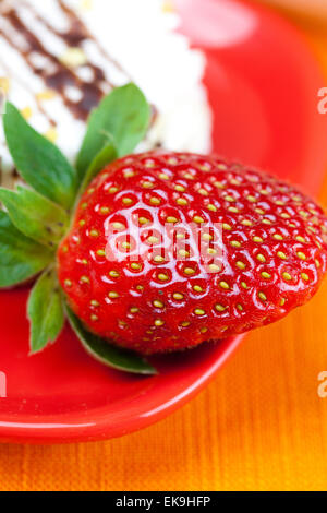 Kuchen und Erdbeeren auf die orangen Stoff liegen Stockfoto