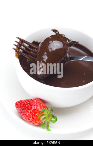 geschmolzene Schokolade in eine Tasse, Gabel und Erdbeeren isoliert auf whi Stockfoto