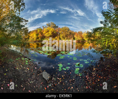Schönen Herbst Sonnenuntergang am Fluss im Wald mit Wolken am blauen Himmel (Ukraine) Stockfoto