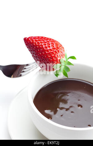 geschmolzene Schokolade in eine Tasse, Gabel und Erdbeeren isoliert auf whi Stockfoto