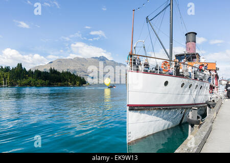 Earnslaw angedockt Queenstowns Lake Wakatipu Passagiere an Bord und bereit, das Dock verlassen. Die gelben Gleitschirm-Hintergrund Stockfoto