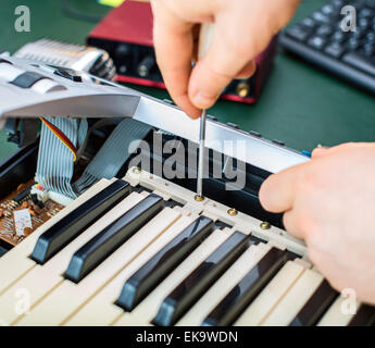 Männliche Hand fixieren MIDI-Keyboard-Controller. Stockfoto