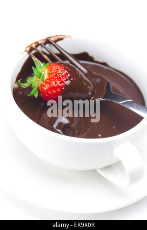 geschmolzene Schokolade in eine Tasse, Gabel und Erdbeeren isoliert auf whi Stockfoto