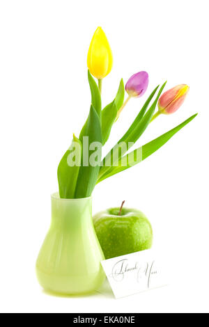 Bunte Tulpen in Vase, Apfel und eine Karte signiert danke isolat Stockfoto