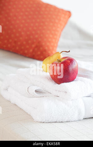 Tasse Tee, Apfel und Birne auf dem Bett Stockfoto