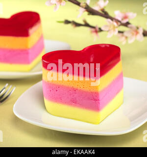 Bunten peruanischen herzförmigen Gelee-Pudding Kuchen namens Torta Helada mit einem blühenden Pfirsich Zweig in den Rücken Stockfoto