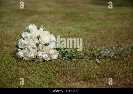 Brautstrauß aus weißen Rosen auf einem grünen Rasen Stockfoto