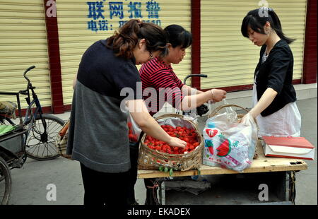 Pengzhou, China: Anbieter verkaufen frische Erdbeeren mit zwei Frauen auf einer Stadt Straße Stockfoto