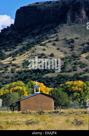 Eine alte Kirche am Fuße des Black Mesa auf San Ildefonso Pueblo verleiht eine romantische und geheimnisvolle Luft, die Farben des Herbstes. Stockfoto