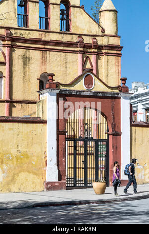 paar in Wanderschuhe pass vor Spanisch kolonialen Kirche San Nicolas gegenüber dem Zocalo San Cristobal de Las Casas Stockfoto