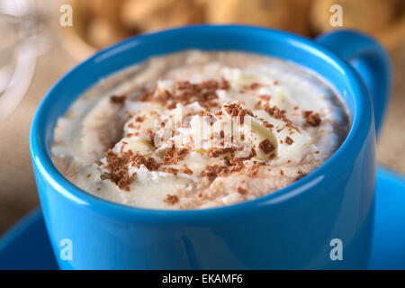 Heiße Schokolade mit Schlagsahne und Schokolade Späne in blauen Tasse mit Cookies in den Rücken (Tiefenschärfe) Stockfoto