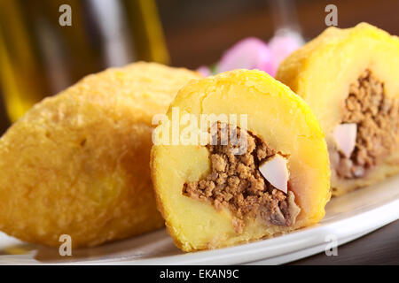 Peruanische Gericht namens Papa Rellena (gefüllte Kartoffel) gebildet von gestampften Kartoffeln und gefüllt mit Fleisch und Ei (Tiefenschärfe) Stockfoto