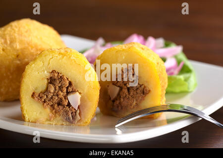 Peruanische Gericht namens Papa Rellena (gefüllte Kartoffel) gebildet von gestampften Kartoffeln und gefüllt mit Fleisch und Ei (Tiefenschärfe) Stockfoto