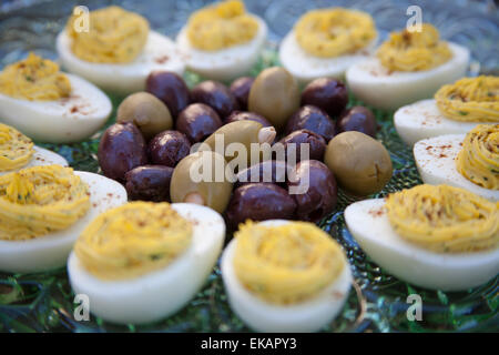 Eingelegte Kalamata-Oliven und grüne Oliven gefüllt mit Knoblauch serviert mit deviled Eiern bestreut mit Paprikapulver Stockfoto