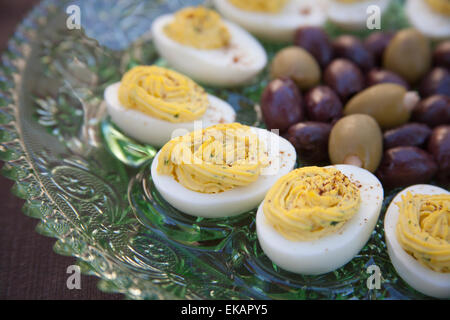 Eingelegte Kalamata-Oliven und grüne Oliven gefüllt mit Knoblauch serviert mit deviled Eiern bestreut mit Paprikapulver Stockfoto