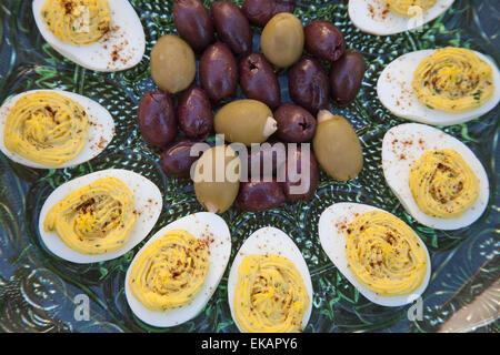 Eingelegte Kalamata-Oliven und grüne Oliven gefüllt mit Knoblauch serviert mit deviled Eiern bestreut mit Paprikapulver Stockfoto