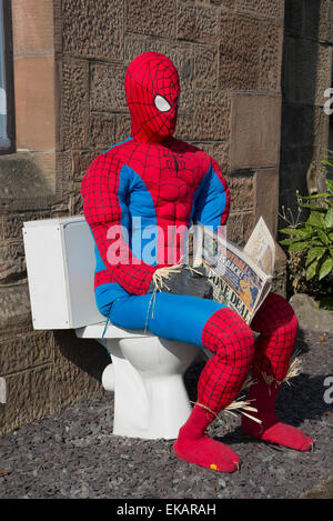 Spiderman Vogelscheuche Scarecrow Festival. Sitzen auf Toilette, die Zeitung lesen. Stockfoto