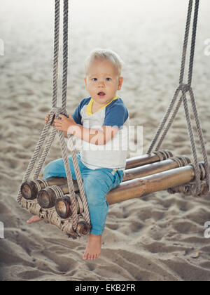 Baby-sitting auf einer Bambus-Schaukel Stockfoto