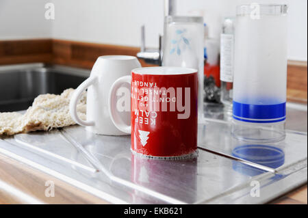 Tassen Becher und Gläser ablassen beim Abwasch Waschbecken in der heimischen Küche Stockfoto