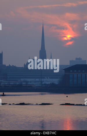 Preston, Lancashire: Die Sonne geht über Preston Docks mit St. Walburge Kirchturm in der Ferne Stockfoto