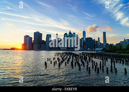 Lower Manhattan Skyline bei Sonnenuntergang, die Überreste der alten Lager Pfähle in den Vordergrund, New York, Vereinigte Staaten von Amerika Stockfoto