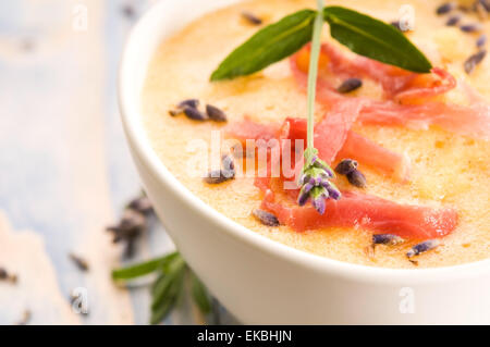 frische Melone Suppe mit Parma Schinken und Lavendel Blume Stockfoto