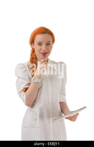 Lächelnde nachdenkliche junge rothaarige Frau Stockfoto