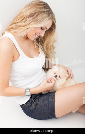 junge Frau mit ihrem blechernen Hund spielen Stockfoto