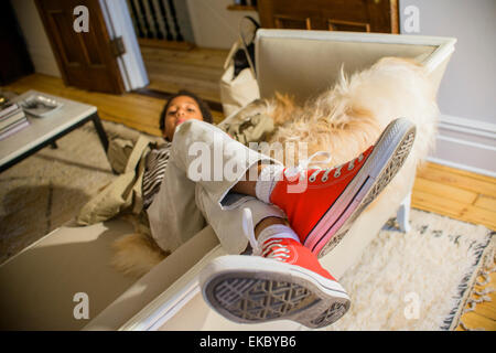 Porträt von laid Back junge mit Füße hoch auf Wohnzimmer-sofa Stockfoto