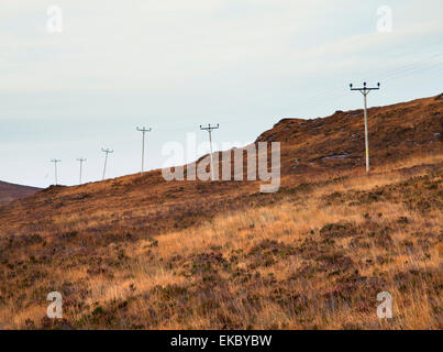 Reihe von elektrischen Masten in abgelegenen Landschaft, North West Highlands, Schottland, Großbritannien Stockfoto