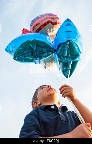 Junge holding Ballons Stockfoto