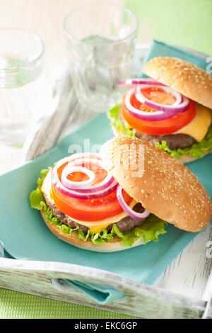 Cheeseburger mit Rindfleisch Patty Käse Salat Zwiebel Tomaten Stockfoto