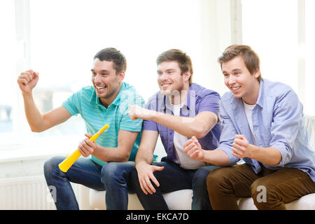 glücklich männlichen Freunde mit Vuvuzela Sport ansehen Stockfoto