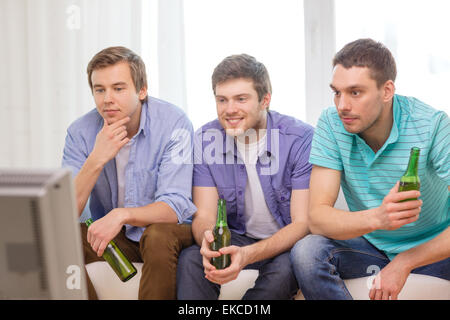 glücklich männlichen Freunde mit Bier vor dem Fernseher zu Hause Stockfoto
