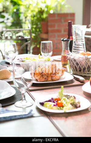 Komplett mit Brathähnchen, Salat, Brötchen, Wein und Obst im Sommer Essen Mahlzeit im Freien. Konzept im Freien speisen. Stockfoto