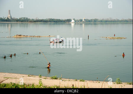 Fischer schlagen die Oberfläche und waten durch das Wasser eines Sees zum Fang in Amarapura in der Nähe von Mandalay Myanmar Stockfoto