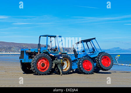 Zwei Traktoren - beschädigt man - im seichten Wasser bei Abersoch, Gwynedd, North Wales, UK Stockfoto