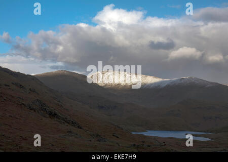 Sonnenlicht fangen die Schnee bedeckten Gipfel des Fairfield von in der Nähe von Easedale Tarn über Grasmere Cumbria England Stockfoto