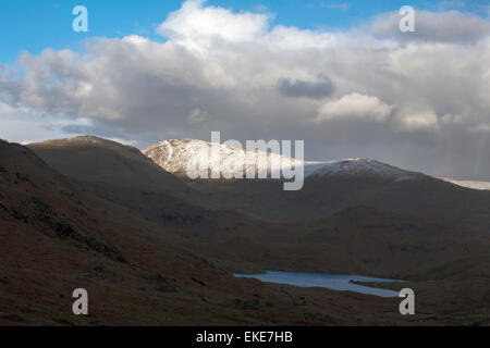 Sonnenlicht fangen die Schnee bedeckten Gipfel des Fairfield von in der Nähe von Easedale Tarn über Grasmere Cumbria England Stockfoto