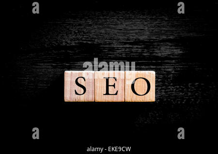 Das Akronym SEO - Search Engine Optimization. Hölzerne kleine Würfel mit Buchstaben auf schwarzem Hintergrund mit Kopie Speicherplatz isoliert. Firmen-Konzept-Image. Stockfoto