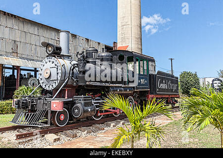 Alte amerikanische Dampfmaschine renoviert und auf dem Display auf ein arbeitendes Museum in Kuba mit der Zuckerrohr-Mühle im Hintergrund Stockfoto