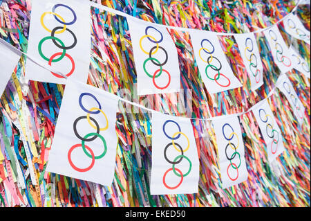 SALVADOR, Brasilien - 11. März 2015: Olympische Flagge Bunting hängt vor dem Hintergrund des guten Glücks brasilianische wünschen Bänder. Stockfoto