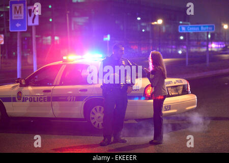 Suitland, USA. 9. April 2015. Ein Journalist spricht mit einem Polizisten auf der Straße neben der U.S. Census Bureau-zentrale nach der Aufnahme passiert beim Büro in Suitland, Maryland, USA, 9. April 2015. Eine Wache in der U.S. Census Bureau-zentrale wurde erschossen und kritisch verwundete Donnerstag, lokale Medien berichteten. Bildnachweis: Yin Bogu/Xinhua/Alamy Live-Nachrichten Stockfoto